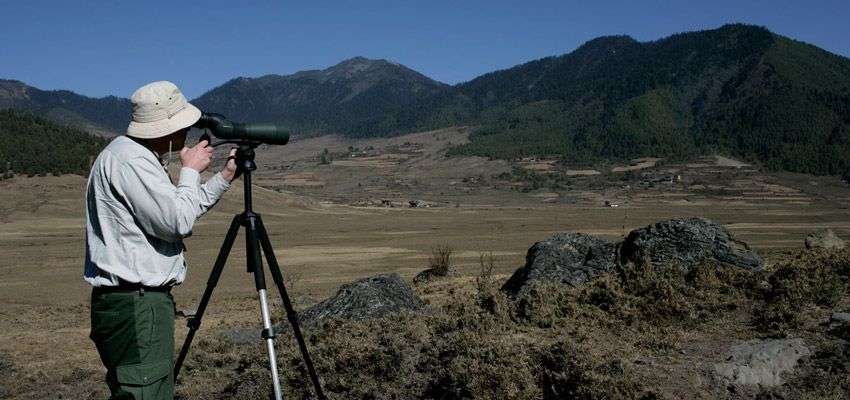 Tourist Spotting Black Necked Crane using Scope